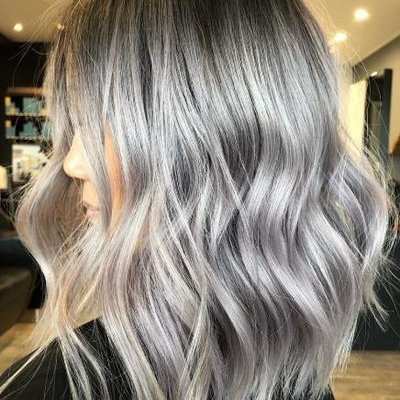 Девушка сушит волосы феном