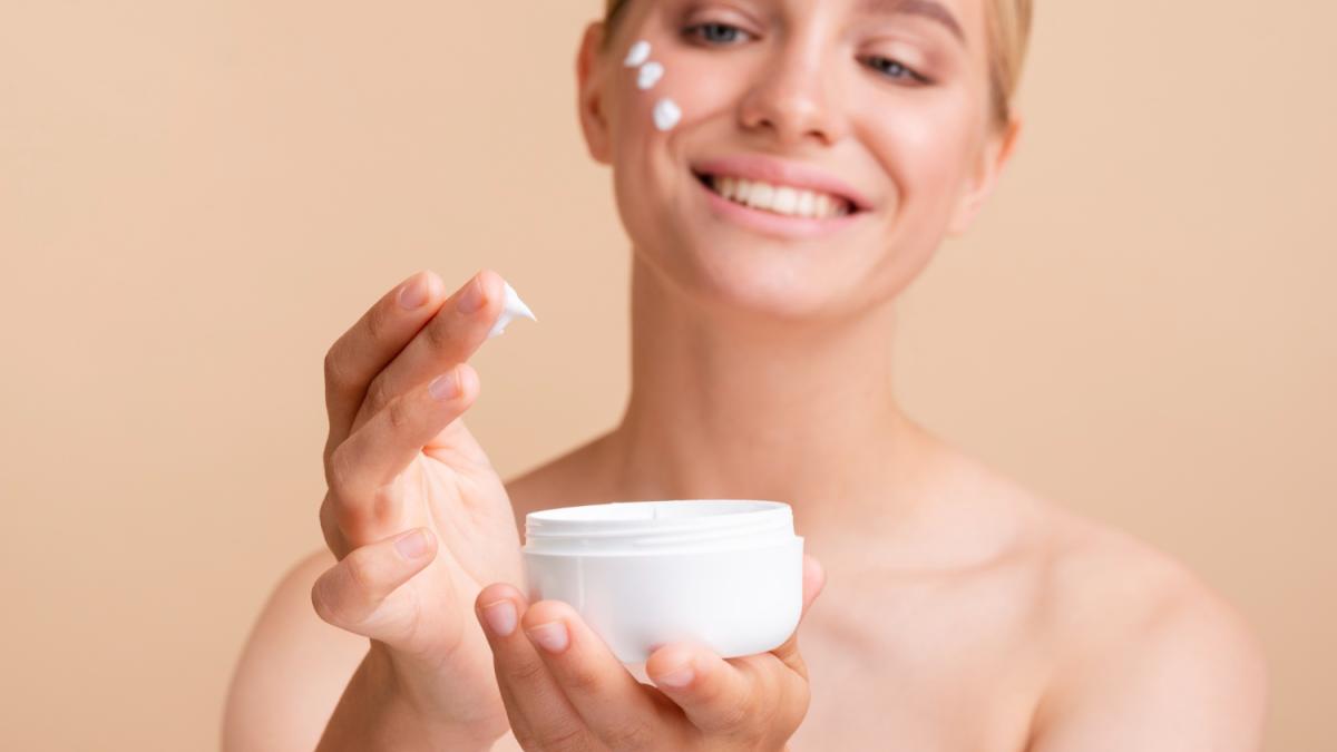 Женщина наносит крем