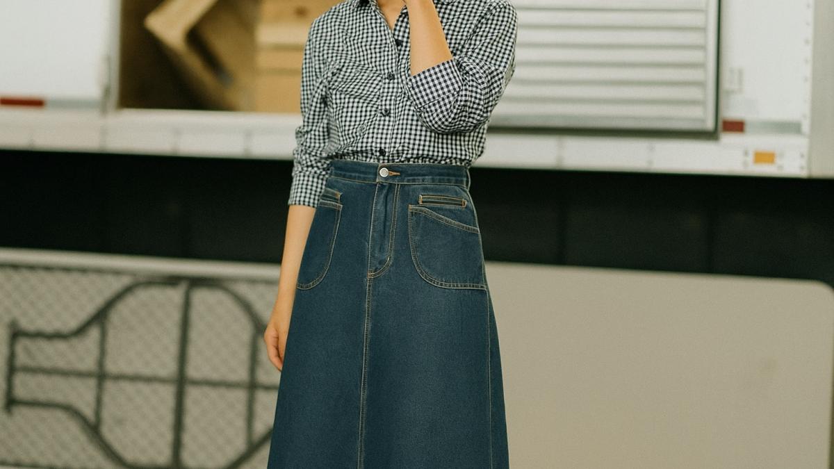 Девушка в длинной джинсовой юбке и клетчатой рубашке