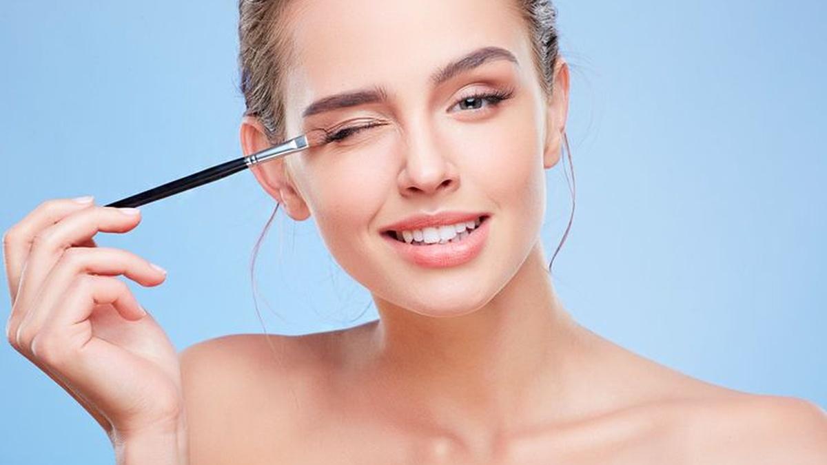 Женщина красит глаза