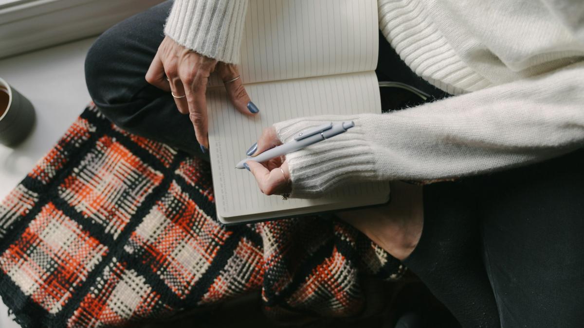 Женщина пишет в блокноте
