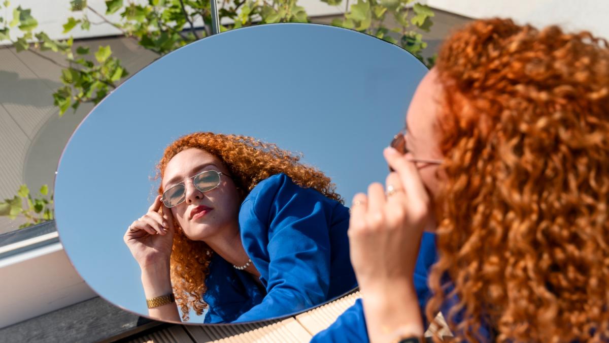 Женщина смотрит в зеркало