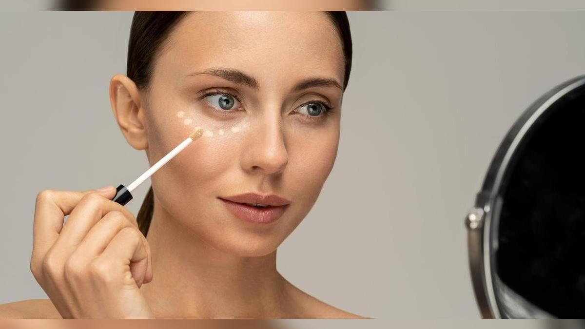 Девушка наносит консилер